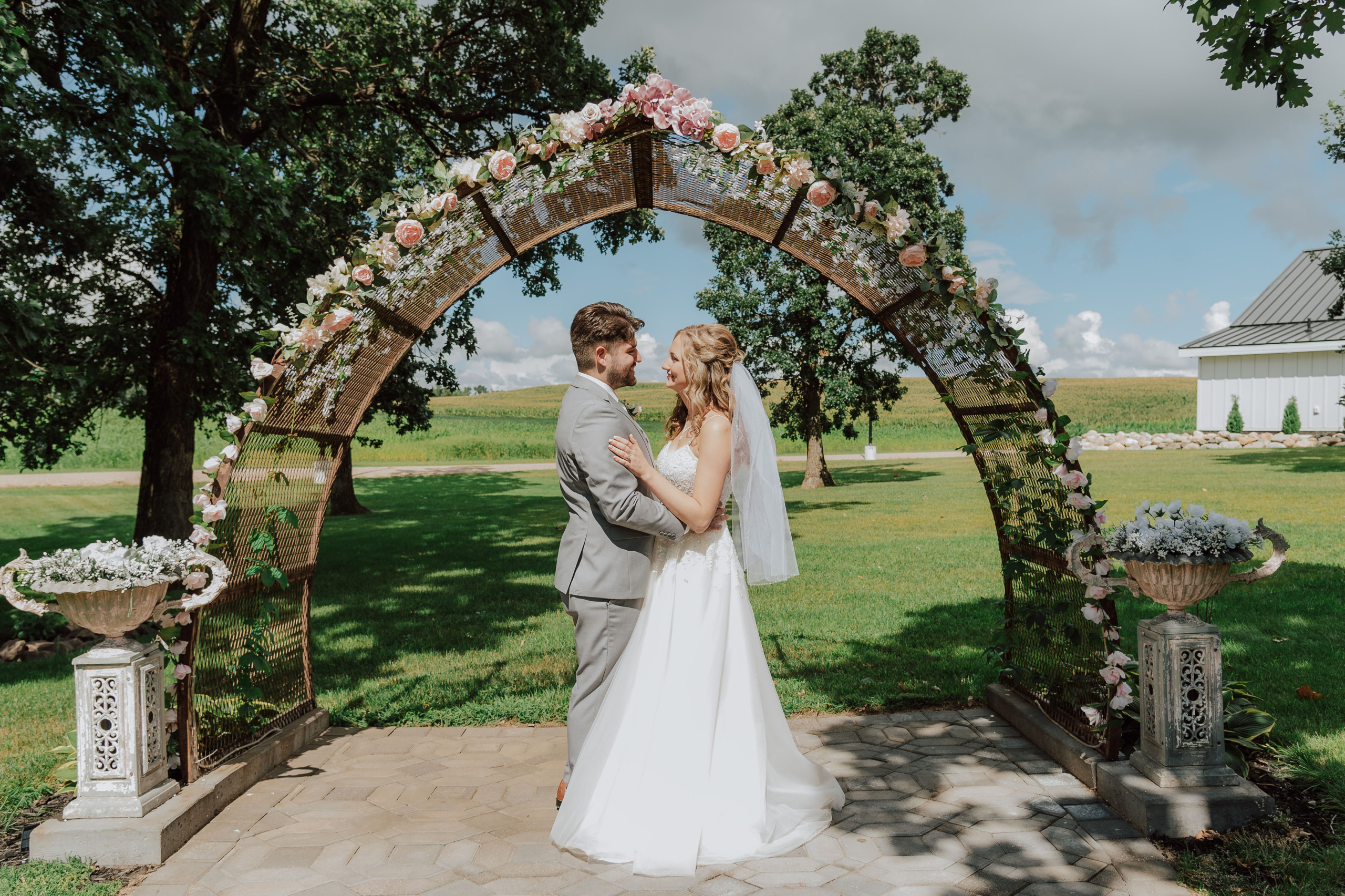 Wedding couple holding each other under a floral arch