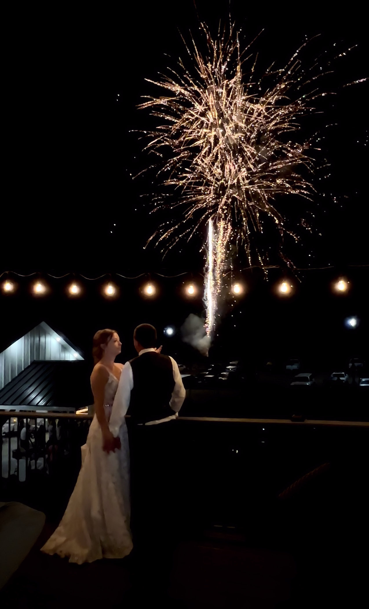 Couple standing on a balcony watching fireworks